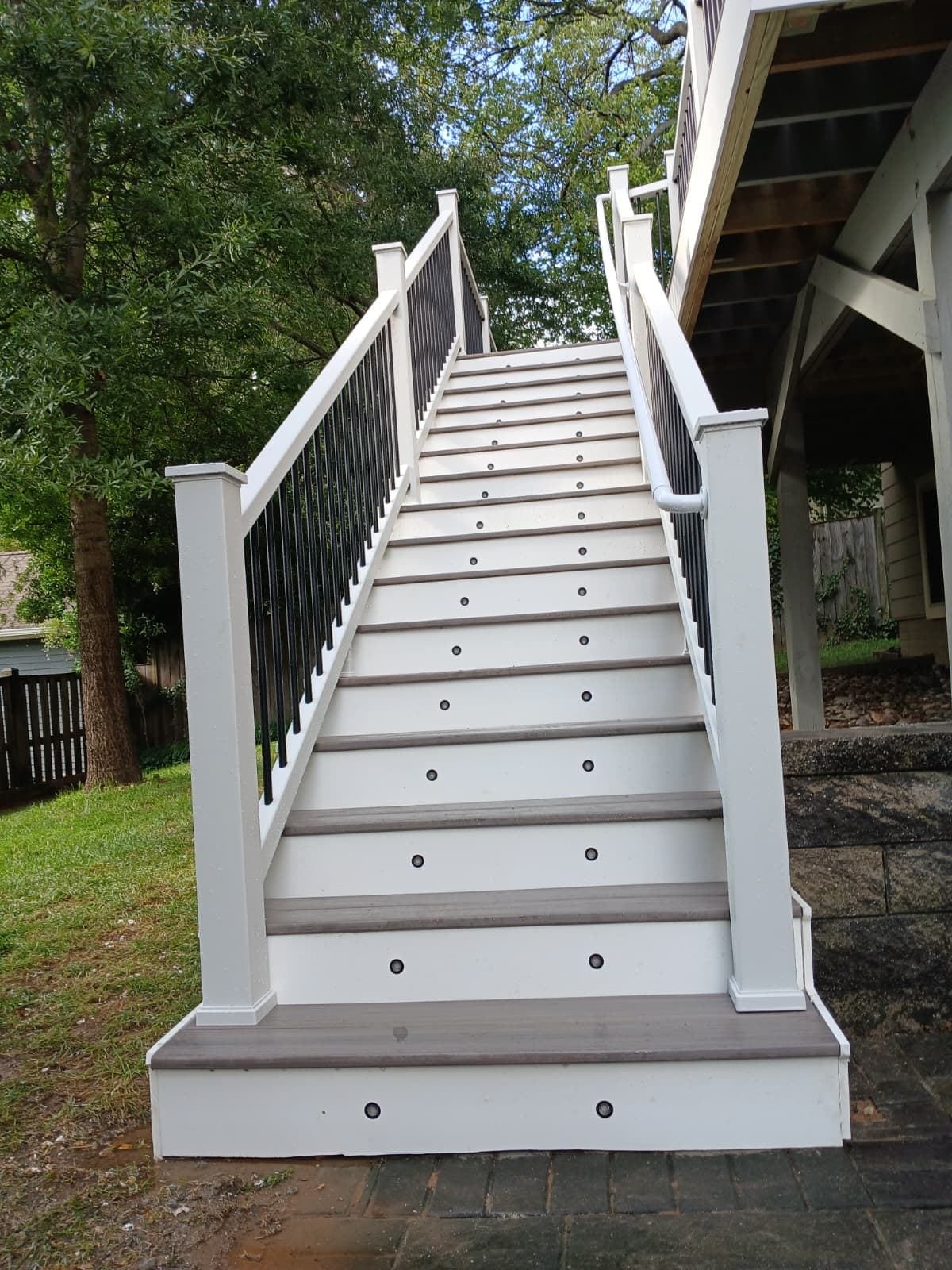 Composite deck stair with white rails and black balusters