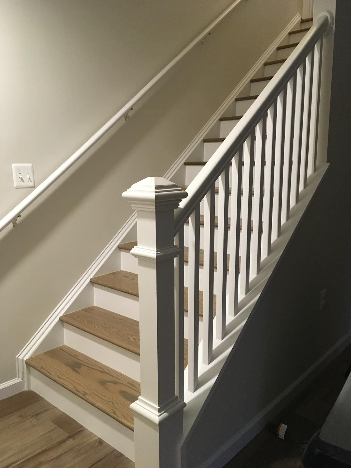 Basement staircase with new wood treads, white risers and a white newel post