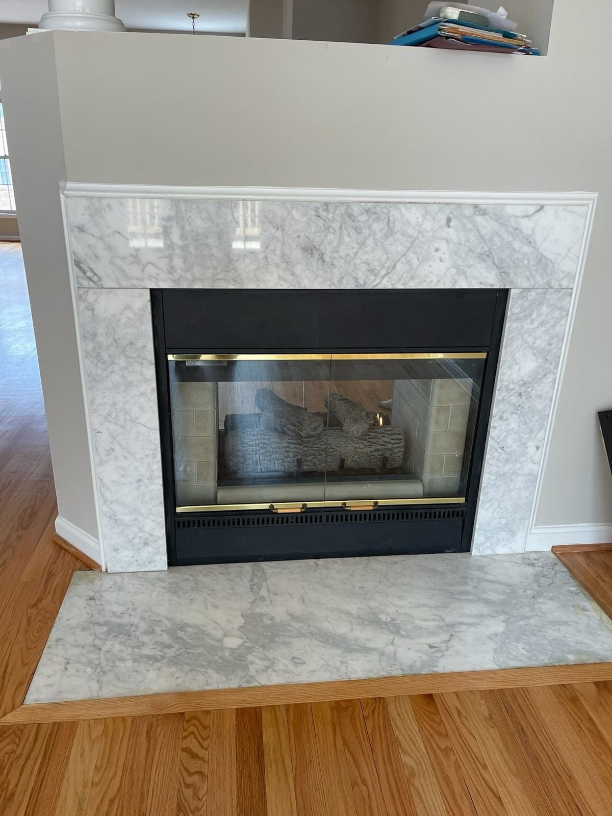 Fireplace refaced in gray marble with a matching marble hearth